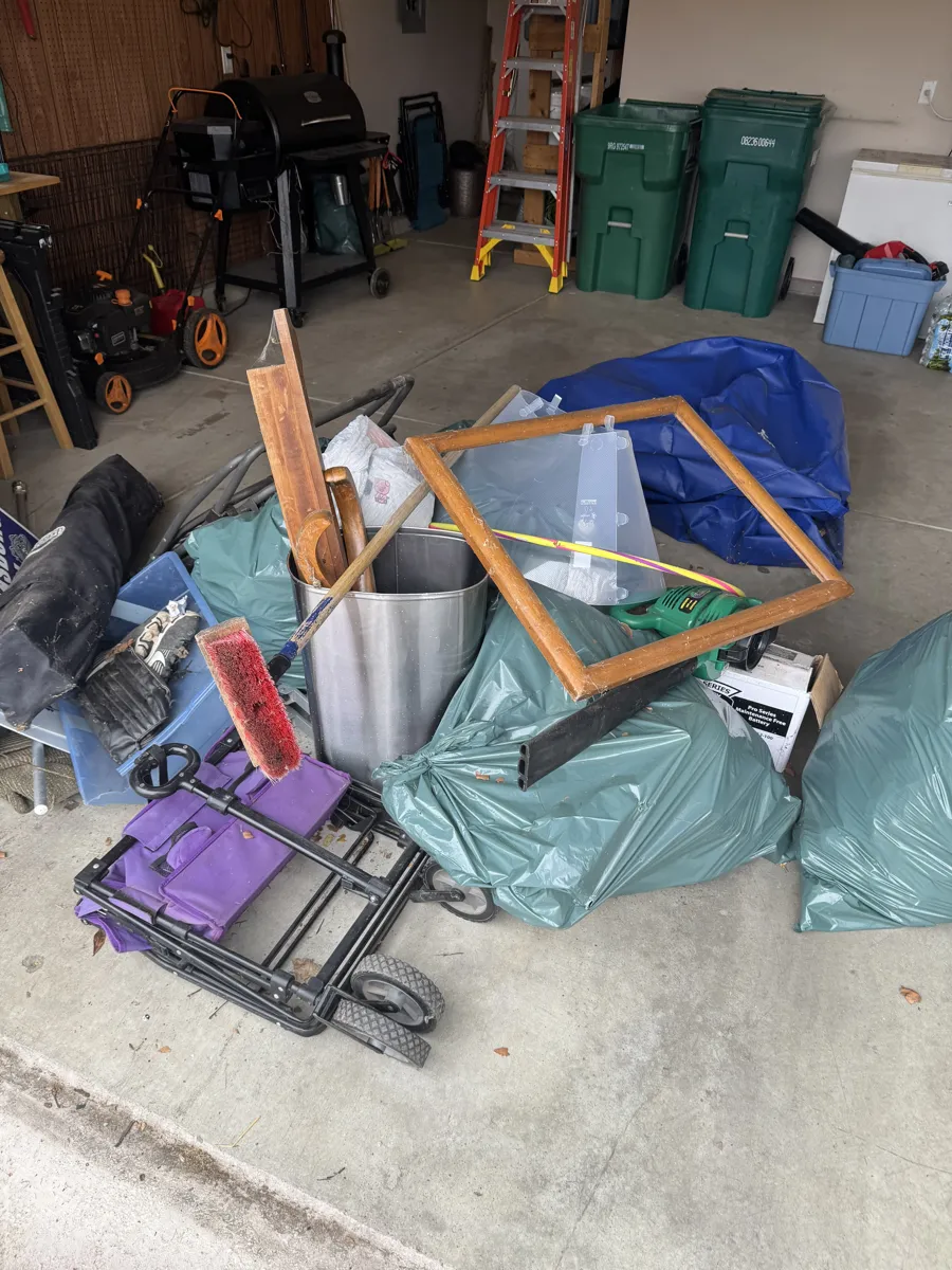Yard tools and trash cans cleared during a garage cleanout