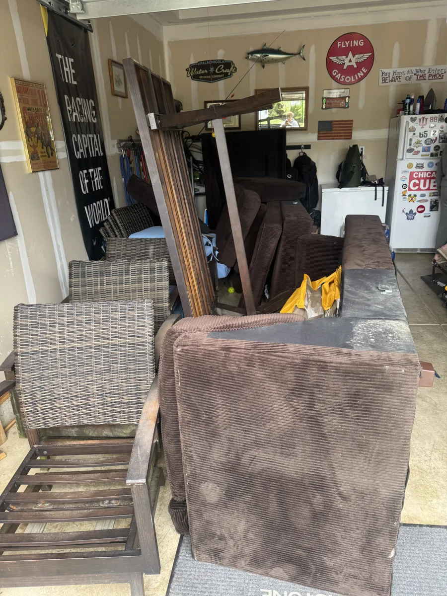 Couch and wicker furniture being removed from a garage